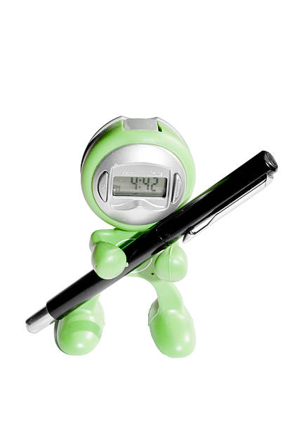 Green human shaped watch holding black pen stock photo