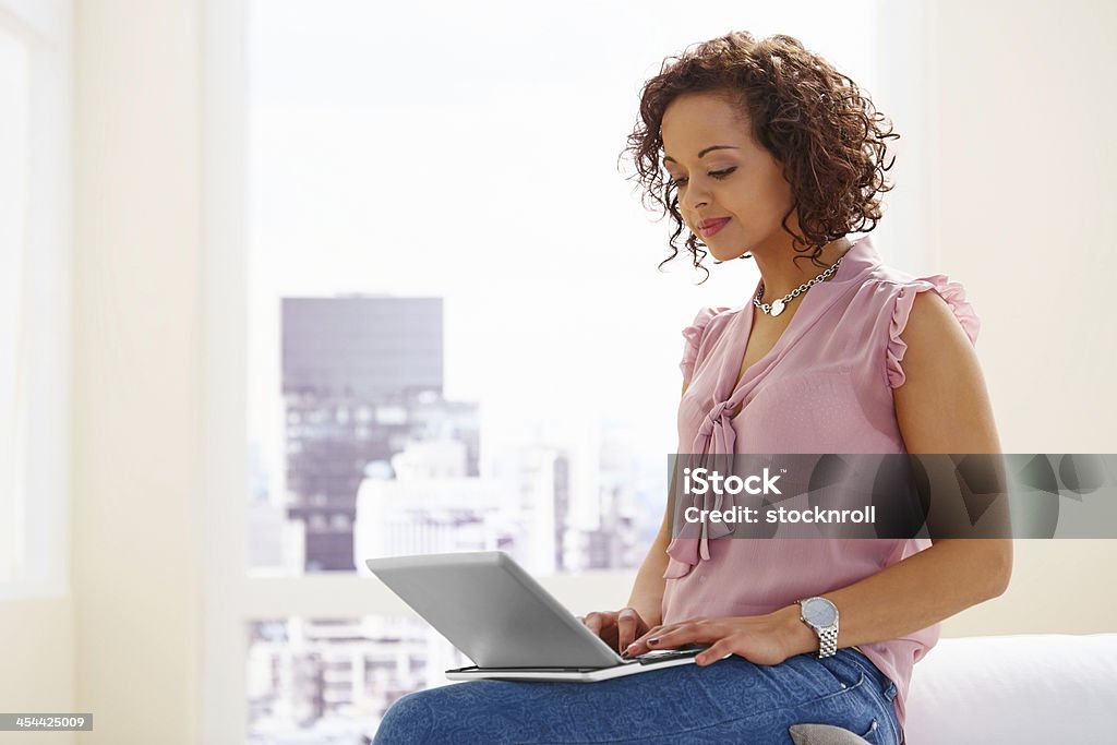 Bella giovane donna che lavora su un computer portatile - Foto stock royalty-free di 20-24 anni