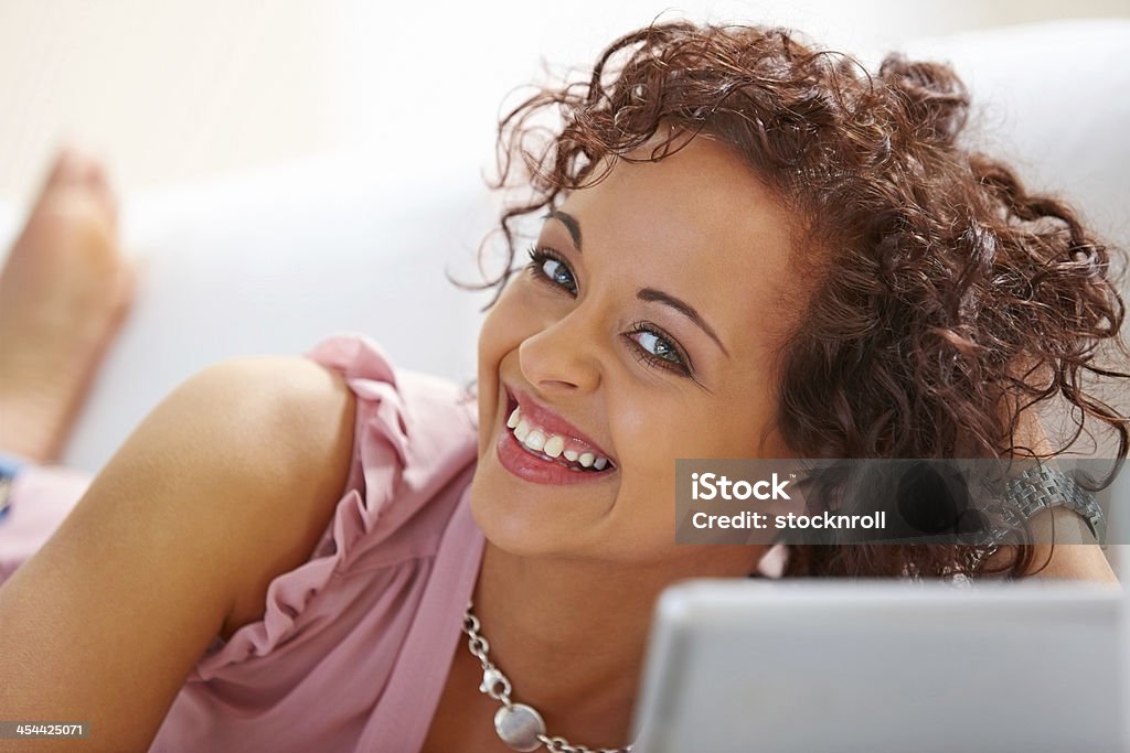 Allegra giovane donna con il computer portatile su un divano - Foto stock royalty-free di 20-24 anni