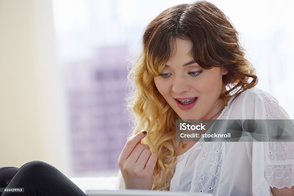 Jolie jeune fille en regardant quelque chose d'intéressant sur Tablette numérique - Photo de 18-19 ans libre de droits