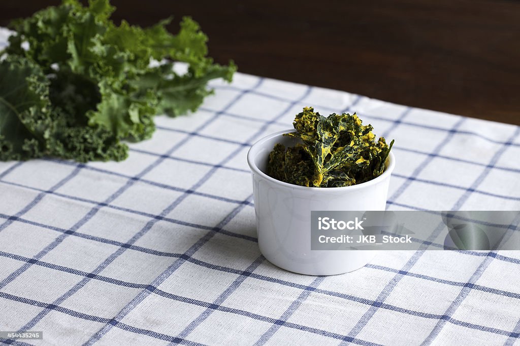 Corbeille de chips de kale sur cuisine serviette - Photo de Chou frisé libre de droits