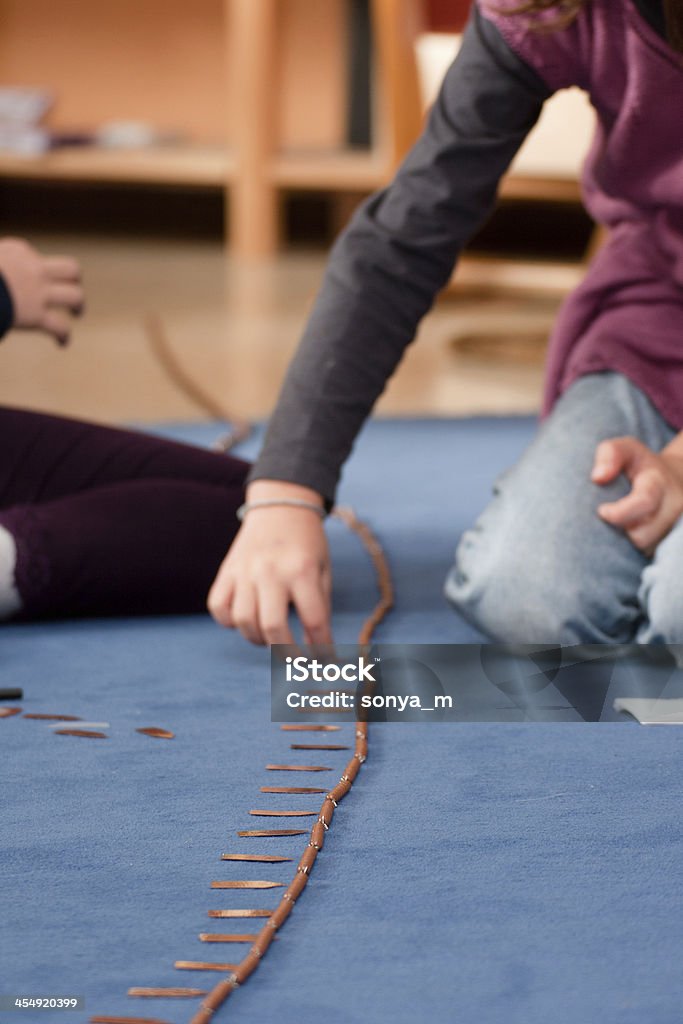 Children Learning Montessori Method Children learning mathematics using montessori equipment in the classrom. Montessori Education Stock Photo