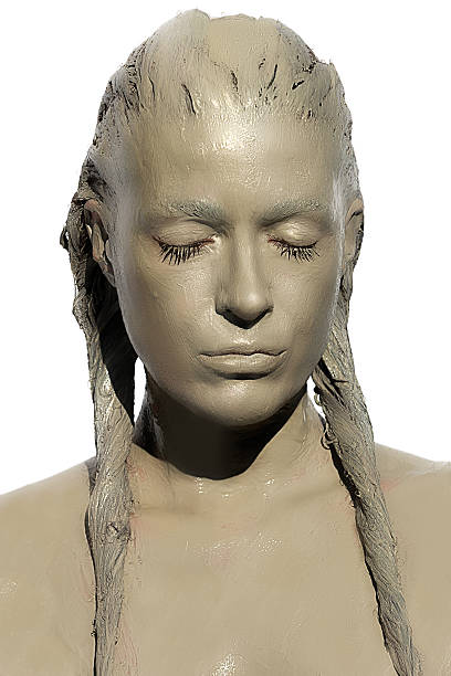 Muddy girl. Clay Woman. Skincare Treatment Portrait of young woman covered in healing clay. Mud rich in minerals: calcium, magnesium, sodium, zinc, potassium, iron, etc. people covered in mud stock pictures, royalty-free photos & images