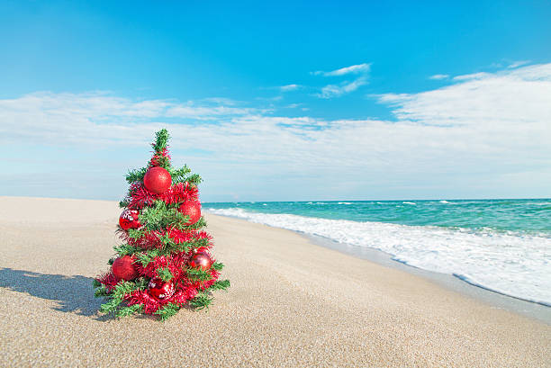 istock Christmas tree with red decorations on the sea beach. 454925163