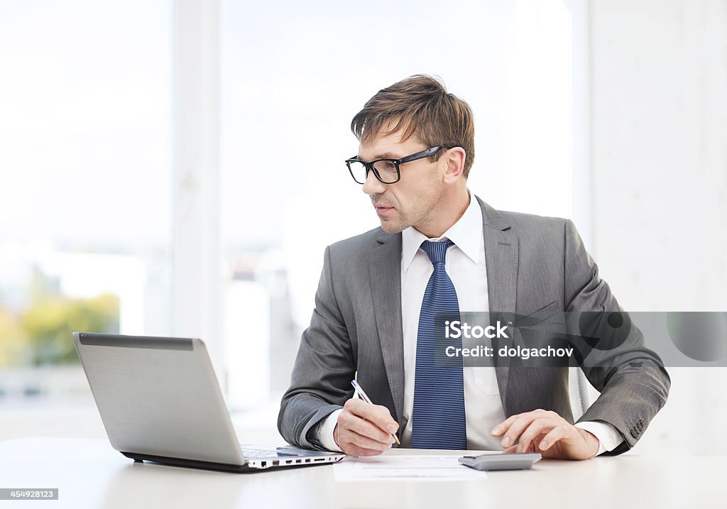 businessman with computer, papers and calculator business, office, school and education concept - businessman with laptop computer, papers and calculator Adult Stock Photo