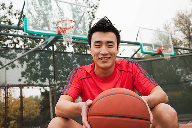 istock Young man sitting with a basketball, portrait 454933151