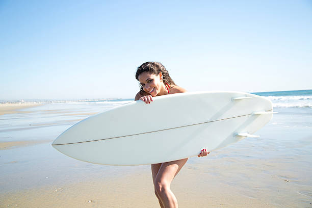 istock Playful beach beauty holding surfboard 454941759