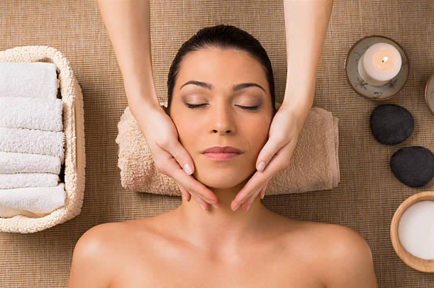 Facial Massage At Spa Beautiful Latin Woman Getting Facial Massage At Spa facial massage stock pictures, royalty-free photos & images