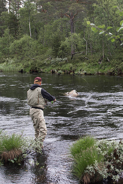 istock Fly fisherman in red cap and vest river 454946191