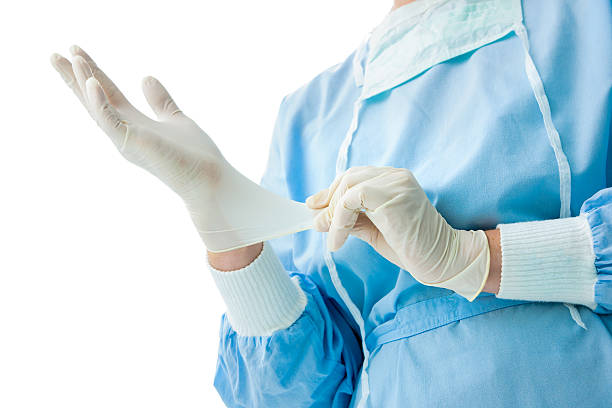 istock Stock photo medical professional pulling on sterile gloves 454955363