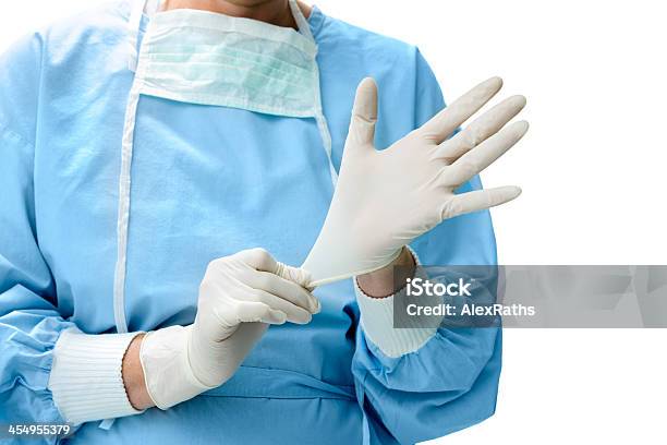 Doctor Putting On Medical Gloves Stock Photo - Download Image Now - Assistance, Blue, Care