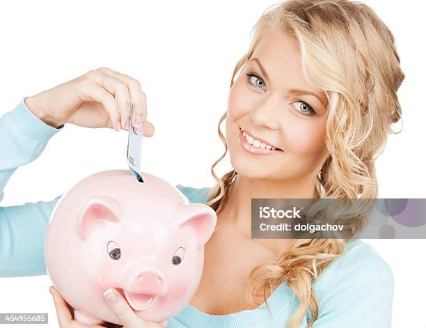 Woman Puts Cash Money Into Big Piggy Bank Stock Photo - Download Image Now - Currency, Large, Miserly