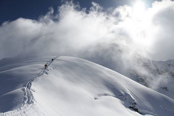 istock Skiers climbing a snowy mountain 454962629