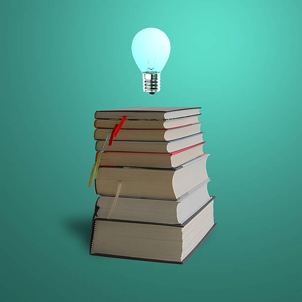 istock Glowing bulb on top of stack books, green background 454962993