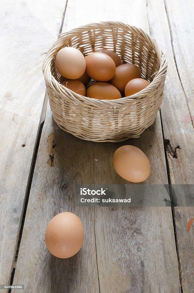 Eggs with basket on wooden floor Front and top shot of eggs with basket on wooden floor Amino Acid Stock Photo