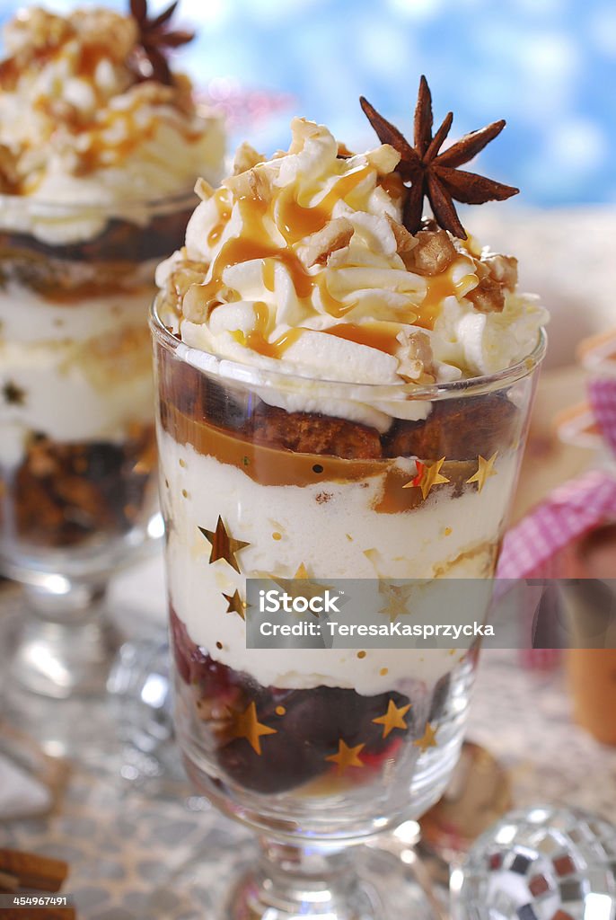 christmas dessert with gingerbread,whipped cream and caramel christmas dessert with gingerbread,whipped cream,caramel,plum and walnuts in glass Parfait Stock Photo