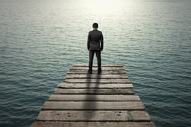 istock Businessman standing and thinking on old wooden pier 454969263