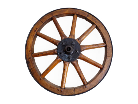 An antique wagon wheel in a barn.