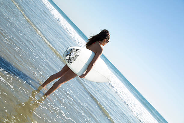 istock California girl holding surfboard 454980519