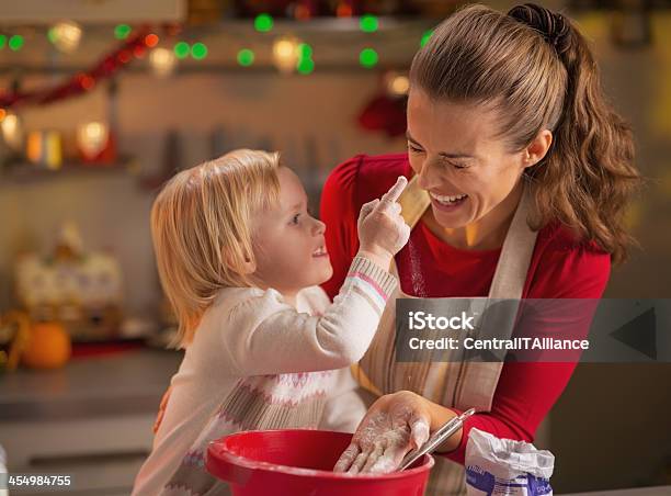 Baby Trying To Smear Mothers Nose With Flour In Kitchen Stock Photo - Download Image Now