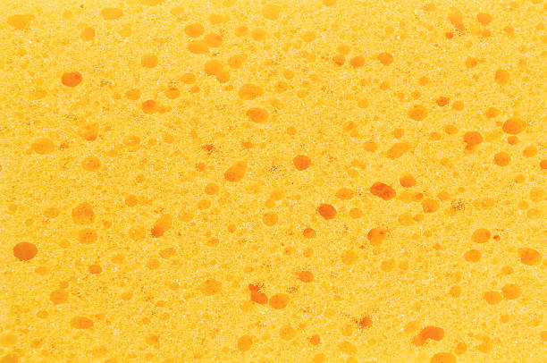 istock yellow sponge with porous texture background 454985543