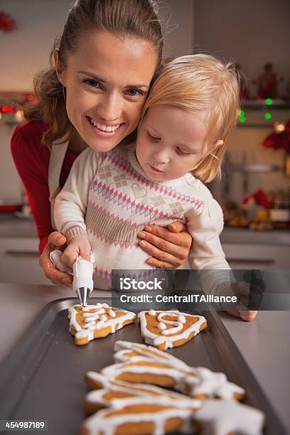 Portrait Of Happy Mother And Baby Decorating Homemade Christmas Cookies Stock Photo - Download Image Now