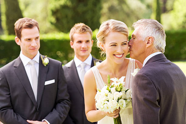istock Father Kissing Bride On Cheek During Outdoor Wedding 454993761