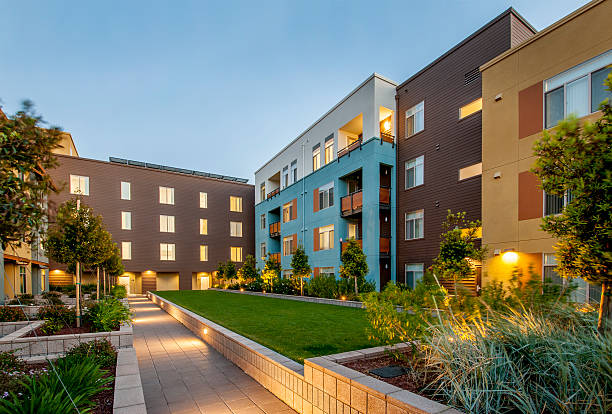 complexe d'appartements, à la tombée de la nuit. - housing development apartment house outdoors photos et images de collection