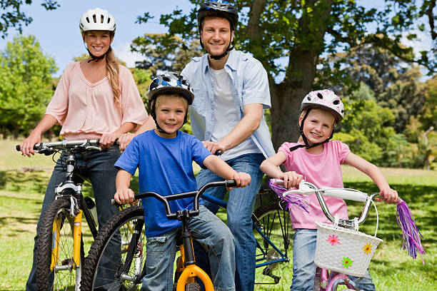 istock Smiling family sitting on their bikes in a park 454998159