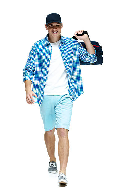 istock Young man walking with gym bag on shoulder 454999493