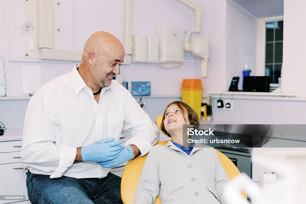 Dentist and smiling patient A young girl visiting the dentist for a check-up.  Adult Stock Photo