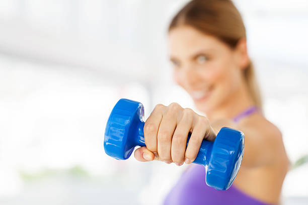 istock Woman Exercising With Dumbbell In Gym 455003467