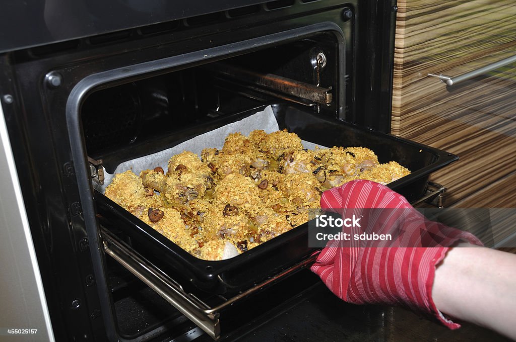 Cosce di pollo arrosto tirare fuori dal forno in Guanto - Foto stock royalty-free di Aglio - Alliacee