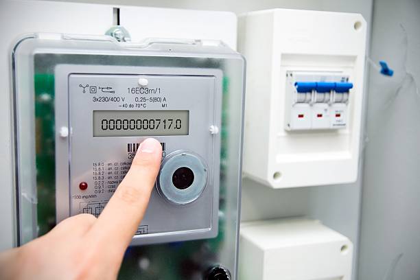 Image of a finger pointing at a modern electric meter 