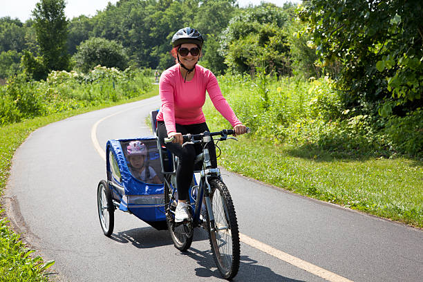 Woman on bike with trailer stock photo