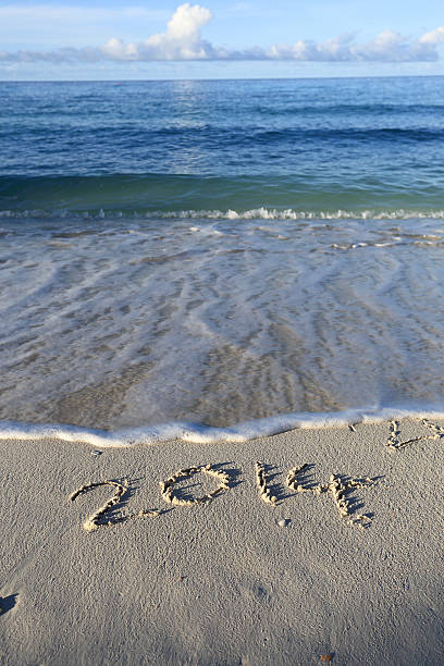 istock Year 2014 written in sand, on tropical beach 455060751