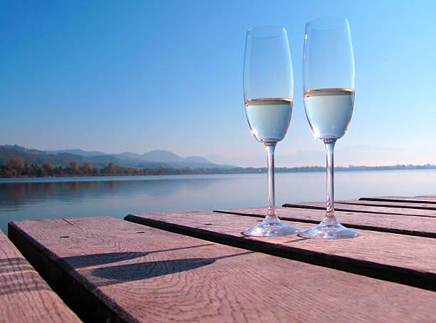 istock Two champagne glasses against a lake 455074441