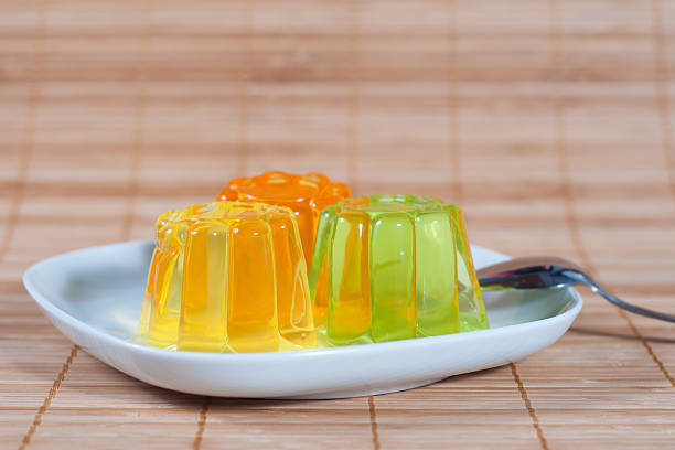 Colorful jelly on white plates over wooden background stock photo