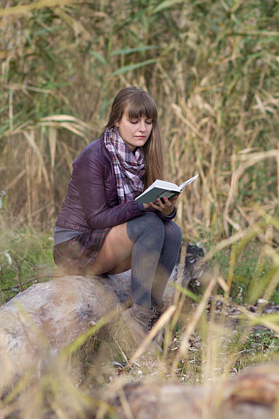 istock Girl with a book on the nature of 455077043