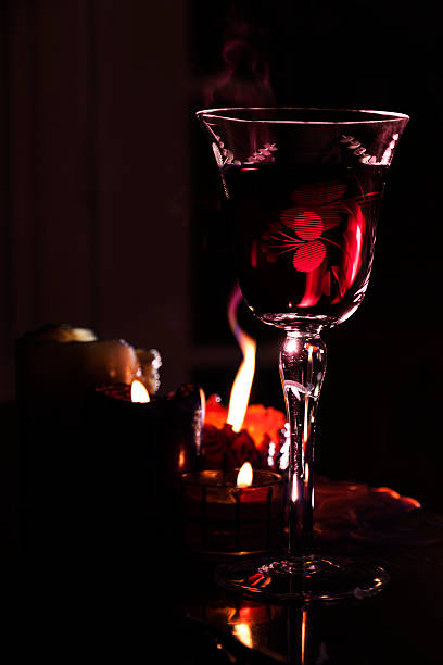 istock Red crystal glass with wine and candles 455092673