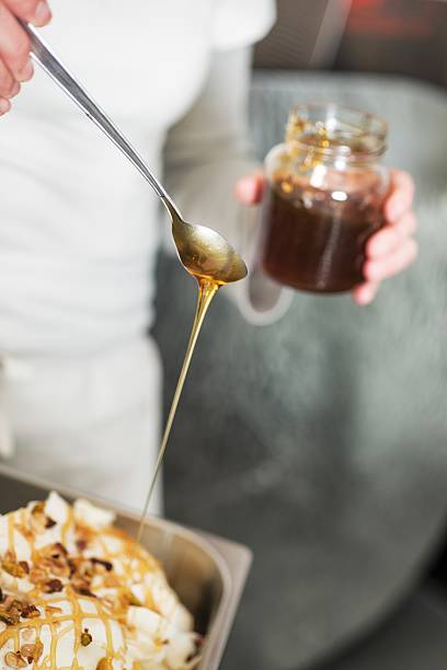 istock Woman Pouring Honey on Ice Cream. 455102273