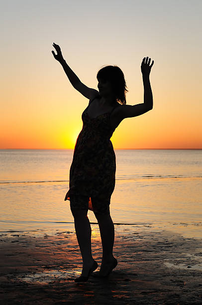 istock Woman as silhouette by the sea 455111421