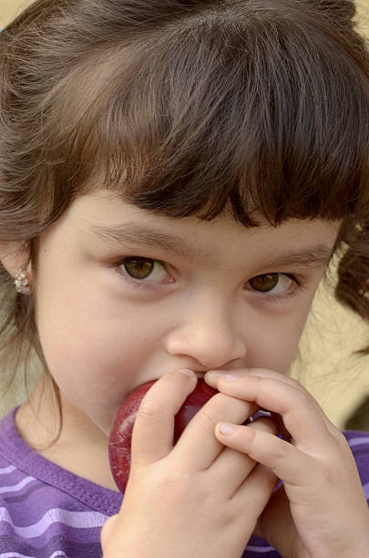 istock Little girl eating an apple 455111525