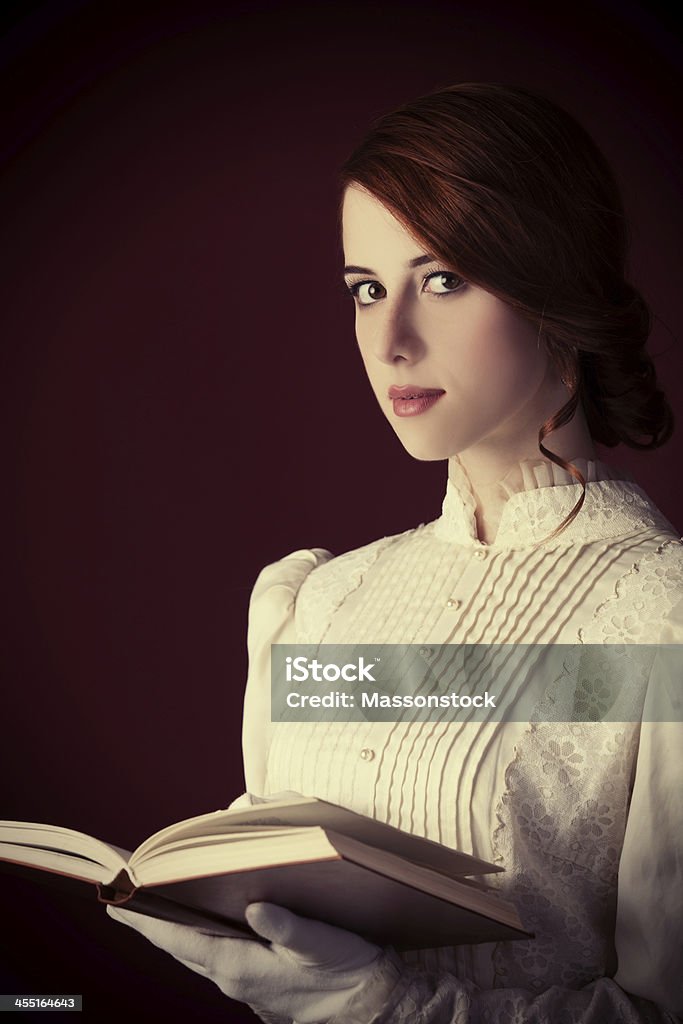 Beautiful redhead women with book Women Stock Photo