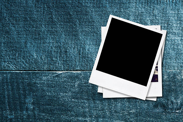 istock Blank photo frames on old wooden background. 455164869