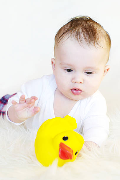 istock baby age of 5 months plays with rubber duckling 455170729