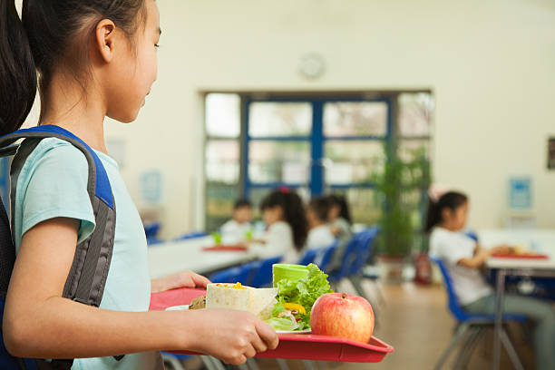 girl holding food tray in school cafeteria - schoollunch stockfoto's en -beelden