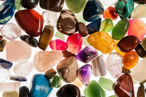 Assortment of polished semi-precious gem stones shot in the studio against white background.