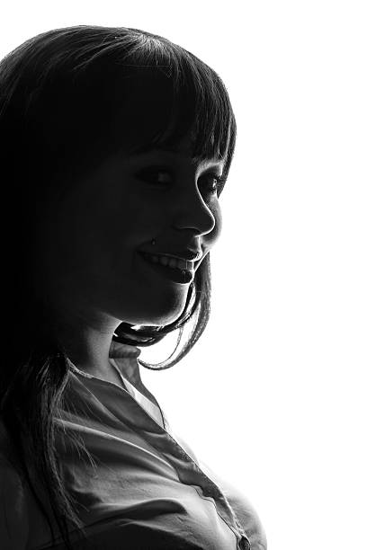 A side profile of a smiling young woman's face. Isolated on white background.