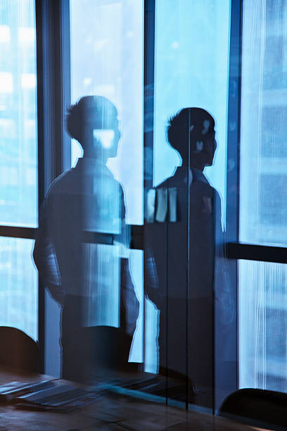 istock Reflection of businessman looking outside the window 455196847